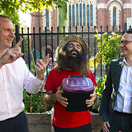 Three people smiling holding a plastic bin caddy