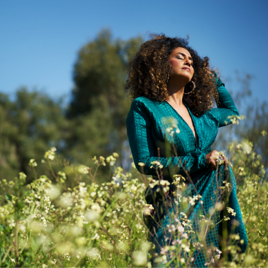 Women with a dreamy look on her face in a field of flowers