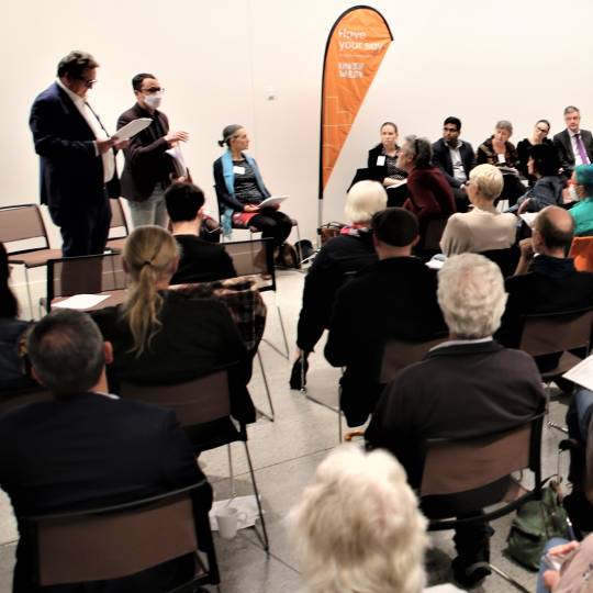 Meeting - people sitting and listening to panel