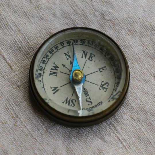 Compass sitting on a cloth material background