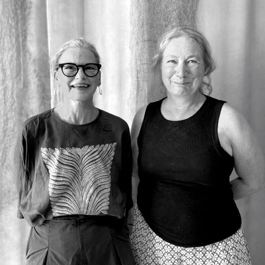 A black and white image of two women smiling at the camera