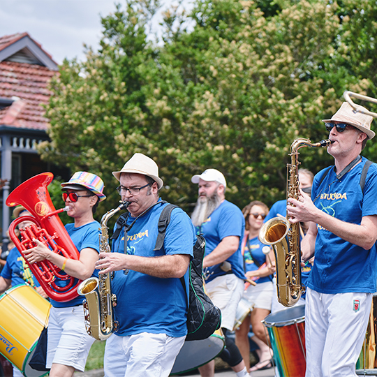 A band of roving performers on a leafy street