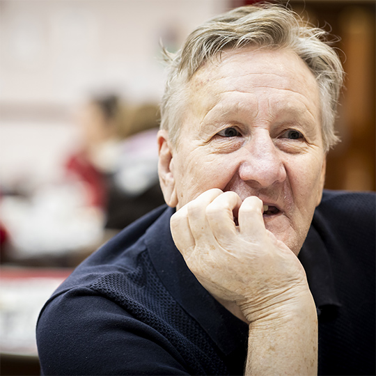 Man sitting with chin resting on his palm.