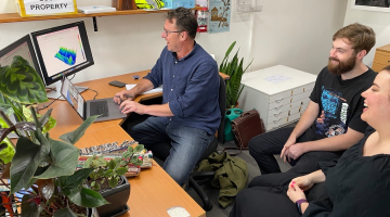 consultant sitting with clients looking at a laptop