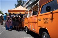 Streetscape featuring a bright orange van branded with the text 