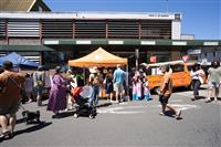 Marrickville streetscape featuring a bright orange van and marquee branded with the text 