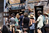 A group of people line up to place their order at a laneway bar