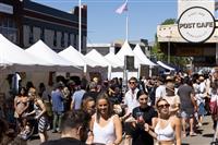 A busy Marrickville streetscape with temporary stalls extending into the distance and lots of people enjoying the spoils of the festival