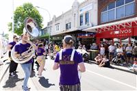 A Marrickville streetscape featuring a brass band wearing purple shirts with branding 