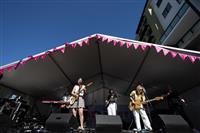 A front of stage shot looking up at three guitarists and one keyboardist, plus an auslan interpreter