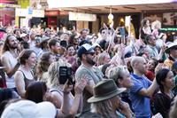 A densely packed crowd enjoying a stage performance off camera, gathered on a Marrickville street