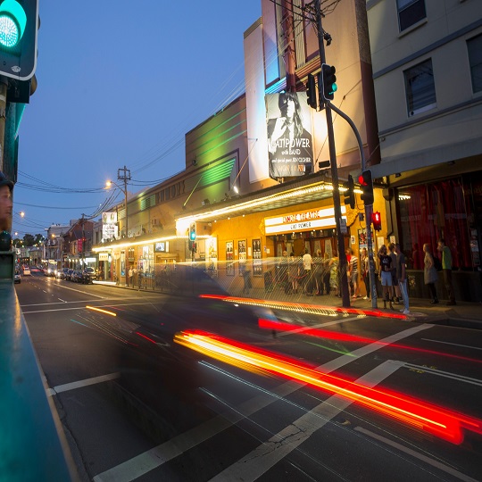 An art deco theatre on a busy urban street at night.