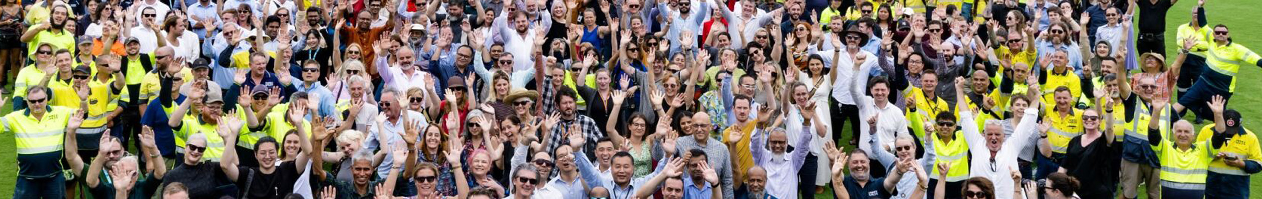 Wide shot of entire Inner West Council team standing together the bleachers of a sports statium