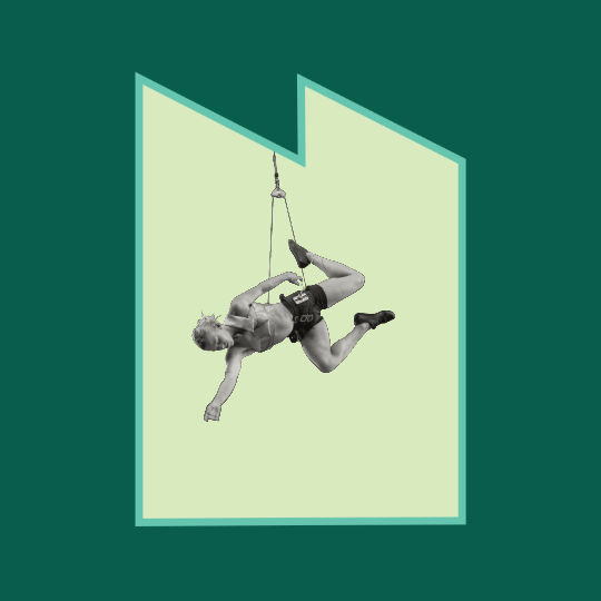 A person in the air, rigged up to an acrobatic rope, with their body pointed horizontally in a flying motion..