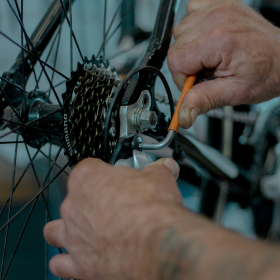 closeup of hands adjusting bike wheel with allen key 