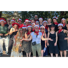choir poses happily outside in the sun