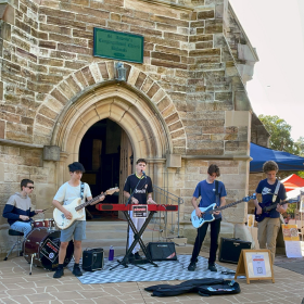 five musicians play outside an old church