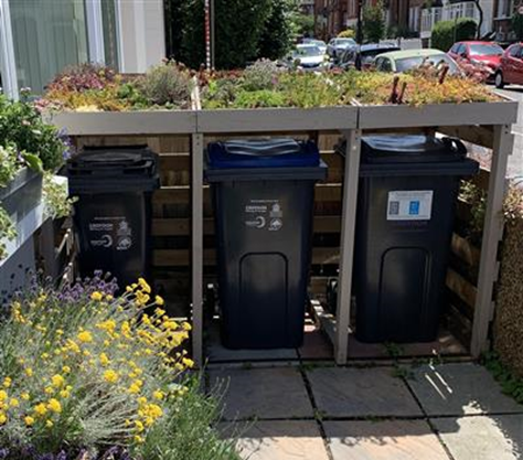 An example of a bin storage area containing three bins underneath a garden