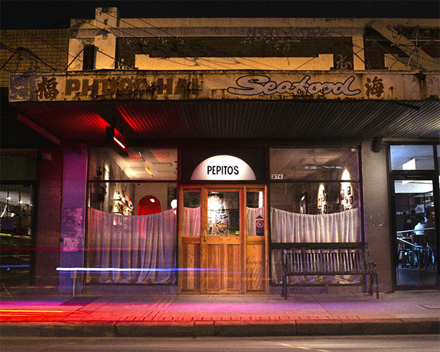 The street frontage of a neighbourhood restaurant/bar at night.