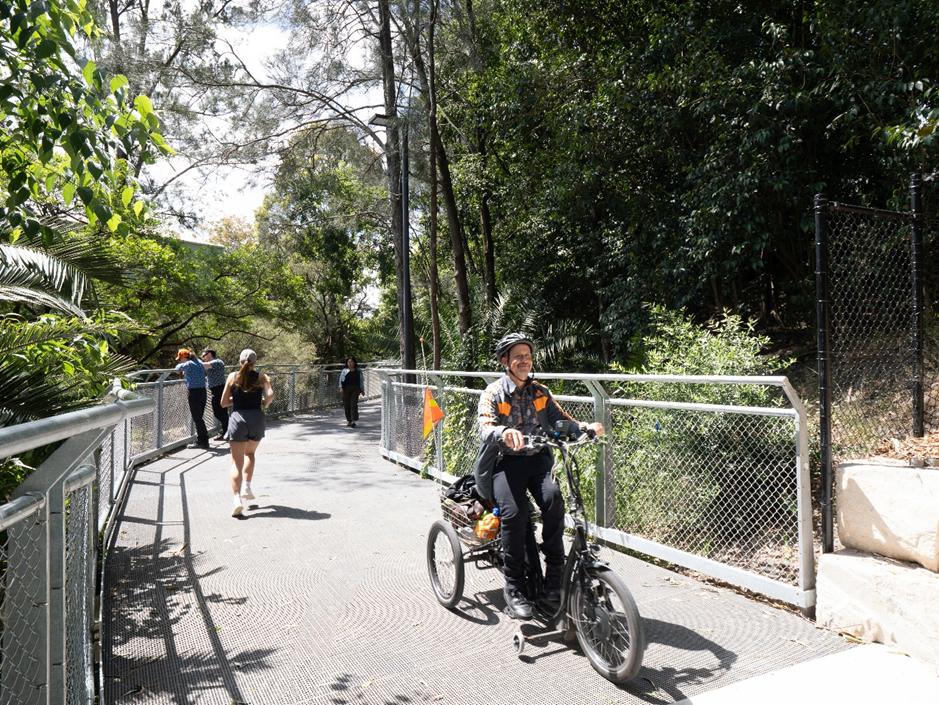 A man on a bike cycling down the greenway path.